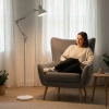 Biała lampa podłogowa AURIQ ST przy sofie w salonie