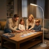 Biała lampa LED TEILO przy fotelu w salonie